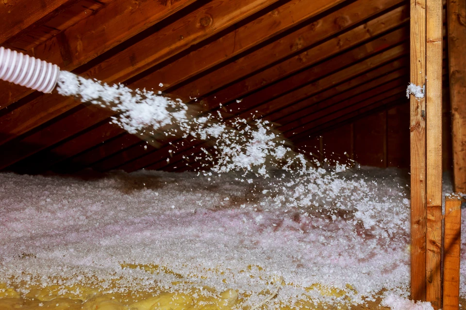 Grenier sous charpente en bois avec projection d'isolant en vrac par soufflage