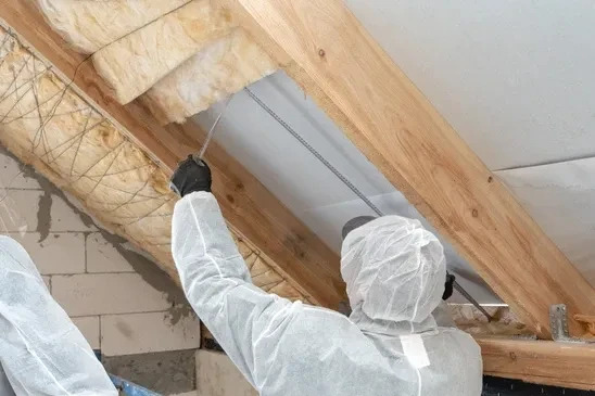 Chantier de construction résidentielle en cours, isolation thermique des combles avec laine de roche entre chevrons apparents